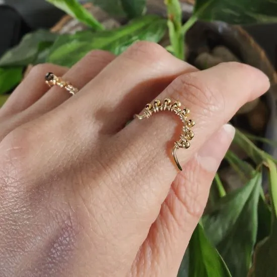 Bague Tiara en fil et perles d’or laminé portée à la main